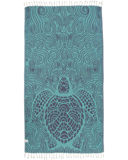 A mint green towel with a swirl turtle design and twisted tassels on the edges.