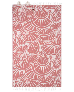 A rectangular woven textile with a repeating scallop or shell-like pattern in dusty pink and off-white, shown flat against a white background. The top and bottom edges have small fringe details, 