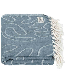 Folded blue patterned towel with white fringe on a white background