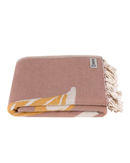 Taupe blanket folded into a square with fringed trim and a brand tag.