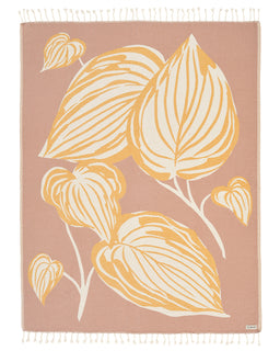 Taupe blanket with a mustard and cream Maranta leaf print, fringed on the top and bottom edges.