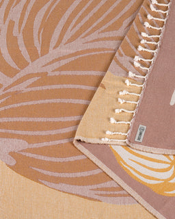 Close-up of a folded corner showing the leaf print fringed edge layered over the reverse side pattern.