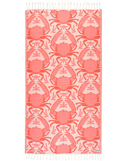 Pink crab patterned towel with white fringe on a white background