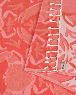 Coral-colored fabric with white floral pattern and brand label.