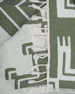 Close-up of a green and white patterned fabric with tassels