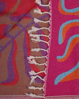 Close-up of a colorful woven fabric with abstract patterns in red, brown, blue, and pink.