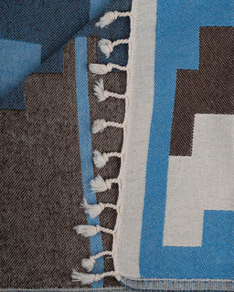 Close-up of a geometric patterned fabric with blue, gray, and brown colors.