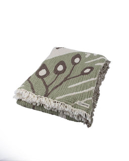 Green blanket with brown leaf pattern on a white background