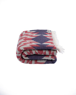 Folded patterned blanket with geometric design on a white background