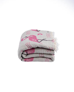 Folded blanket with pink flamingo design on a white background