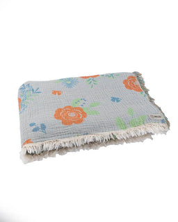 Floral patterned blanket with fringe on a white background
