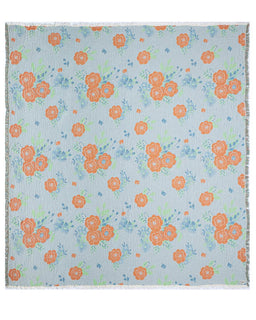 Floral patterned fabric with orange flowers on a light blue background