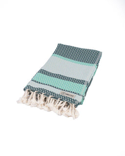 Folded towel with a pattern and tassels on a white background