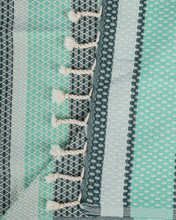 Close-up of a textured fabric with geometric patterns in green, blue, and gray.