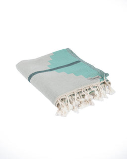 Turquoise and gray towel with tassels on a white background