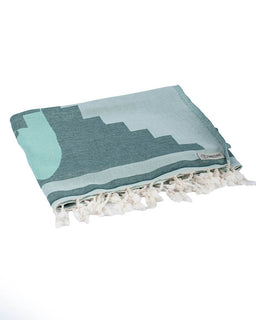 Teal and white patterned towel with tassels on a white background