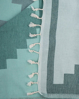 Teal and gray patterned fabric with tassels on a teal background