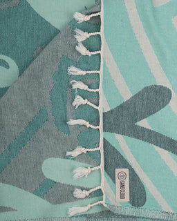 Teal and gray patterned fabric with tassels and a brand label.