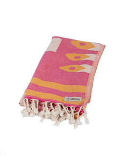 Pink and yellow patterned towel with white tassels on a white background