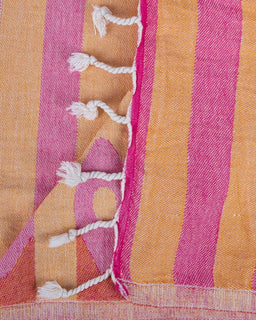 Close-up of a fabric with pink and orange stripes and white tassels.