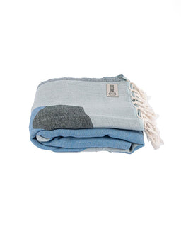 Folded blue and gray towel with tassels on a white background