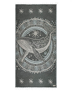 Decorative towel with whale design and star patterns on a dark background