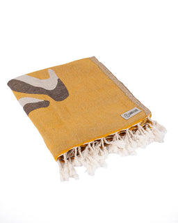 Yellow towel with fringe and abstract design on a white background