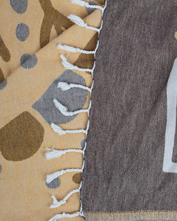 Close-up of a fabric with a patterned edge transitioning from beige to gray.