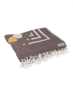 Brown towel with white geometric design and fringes on a white background