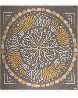 Decorative towel with a circular pattern in brown, yellow, and white on a brown background.