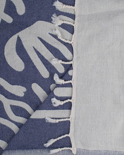 Textile with hand-patterned design and tassels on a blue and gray background