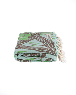 Folded blanket with a leaf pattern on a white background