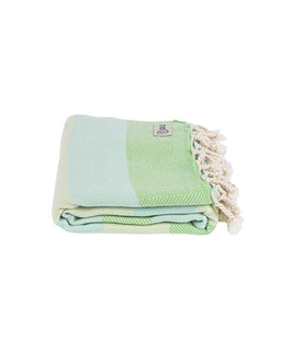 Folded green and light blue towel with tassels on a white background