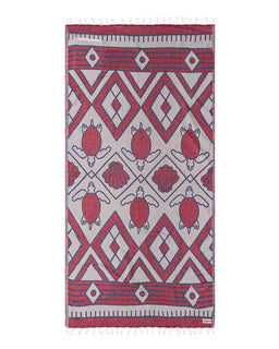 Towel with red and white geometric pattern featuring turtles and shells on a white background