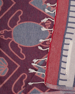 Close-up of a patterned fabric with geometric designs in red, blue, and white.