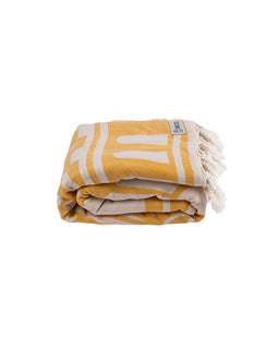 Yellow and white patterned towel with fringes on a white background