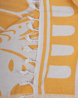 Close-up of a yellow and white patterned fabric with frayed edges.