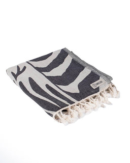 Gray and white patterned towel with tassels on a white background
