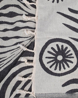 Close-up of a fabric with black and white patterns, including zebra stripes and circular designs.