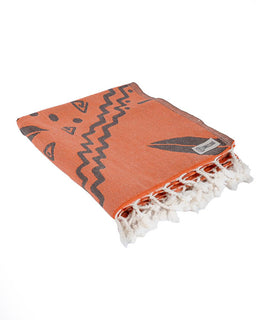 Orange towel with black patterns and white fringes on a white background