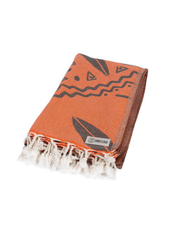 Orange towel with black patterns and white fringes on a white background