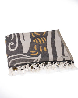 Textile with abstract pattern and fringes on a white background