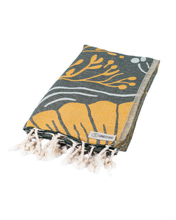 Floral patterned towel with tassels on a white background
