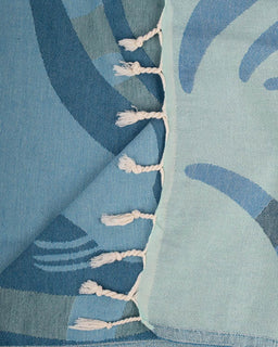 Close-up of a blue fabric with tassels and abstract patterns