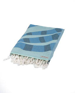 Blue patterned towel with white fringes on a white background