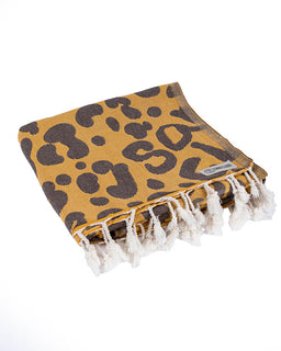 Leopard print towel with white tassels on a white background