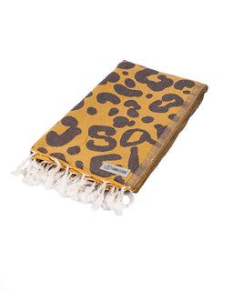 Yellow towel with black abstract pattern and white fringe on a white background