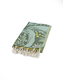 Green towel with leaf pattern and white fringe on a white background