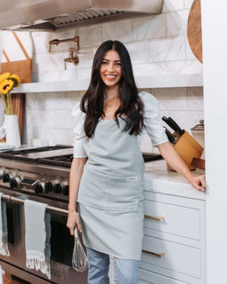 Girl with sage apron in kitchen
